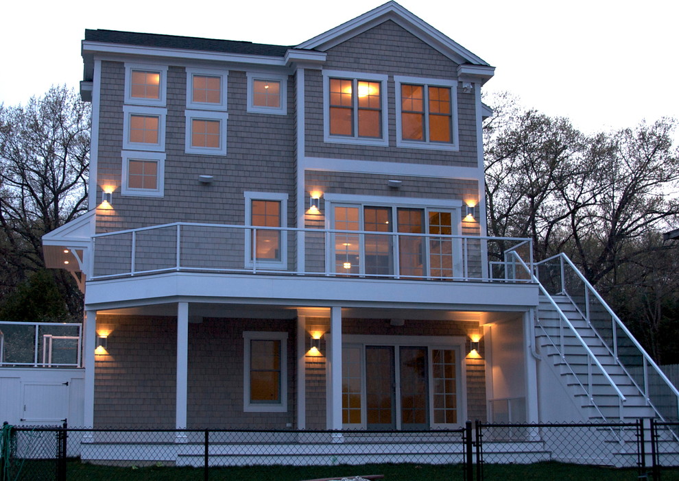 Idée de décoration pour une façade de maison grise design en bois à deux étages et plus avec un toit à deux pans.