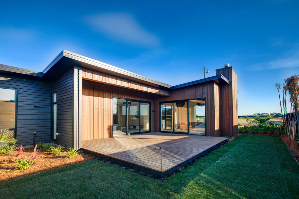 Aménagement d'une grande façade de maison marron scandinave en bois de plain-pied avec un toit plat et un toit en métal.