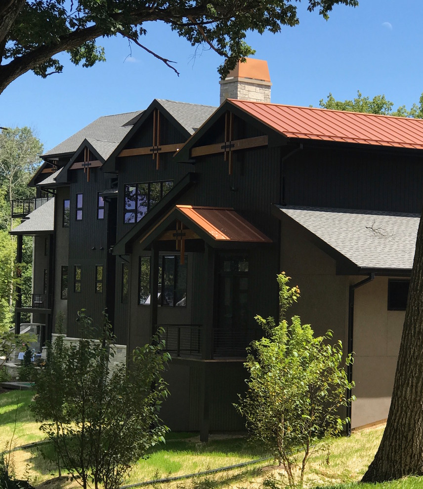 На фото: большой, трехэтажный, черный частный загородный дом в современном стиле с комбинированной облицовкой, двускатной крышей и крышей из смешанных материалов