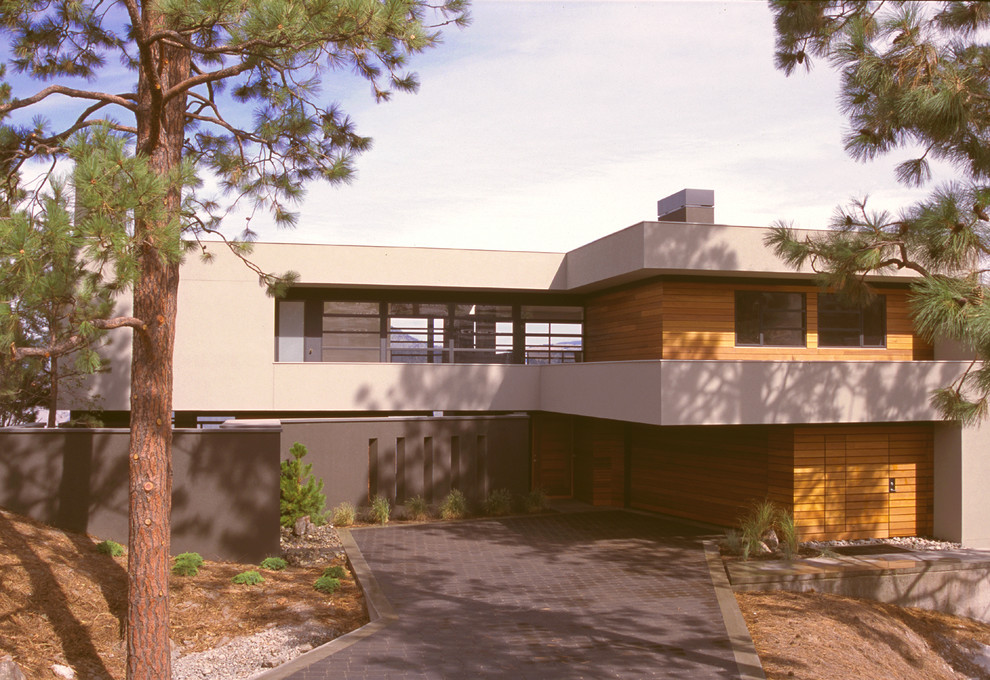 Cette photo montre une grande façade de maison marron tendance à deux étages et plus avec un revêtement mixte et un toit plat.