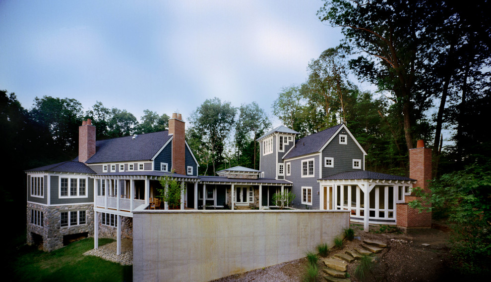 Cette image montre une grande façade de maison bleue traditionnelle à deux étages et plus avec un revêtement mixte et un toit à deux pans.