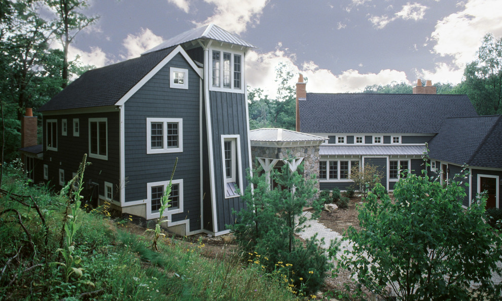 На фото: большой, трехэтажный, синий дом в стиле неоклассика (современная классика) с комбинированной облицовкой и двускатной крышей с