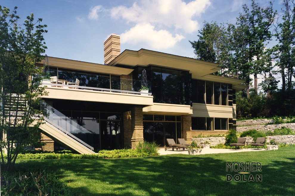 Inspiration pour une très grande façade de maison beige design en brique à deux étages et plus avec un toit plat.