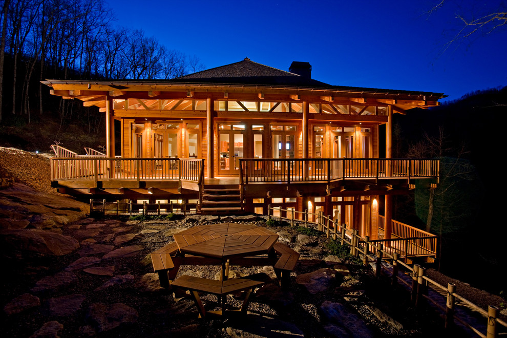 Foto della facciata di una casa ampia marrone american style a tre piani con rivestimento in legno e tetto a capanna