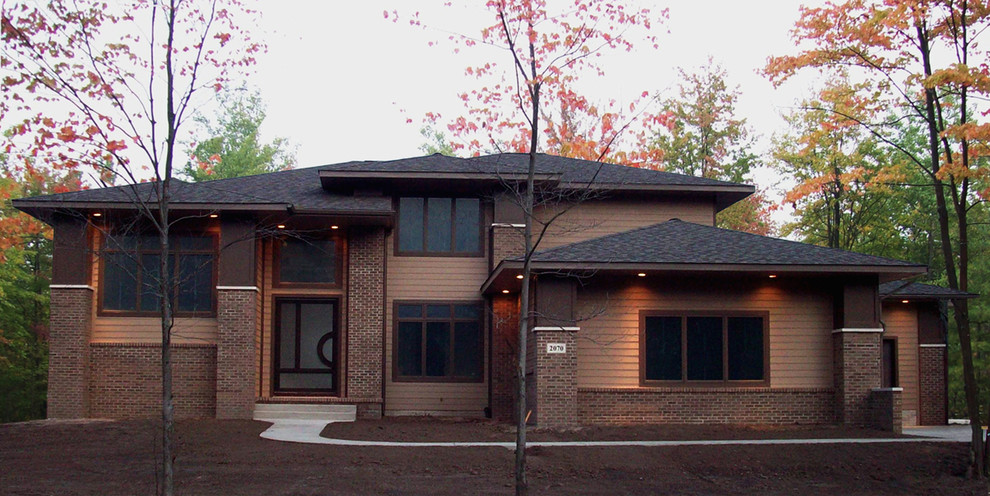 Example of a mid-sized transitional brown two-story concrete fiberboard house exterior design in Other with a hip roof and a shingle roof