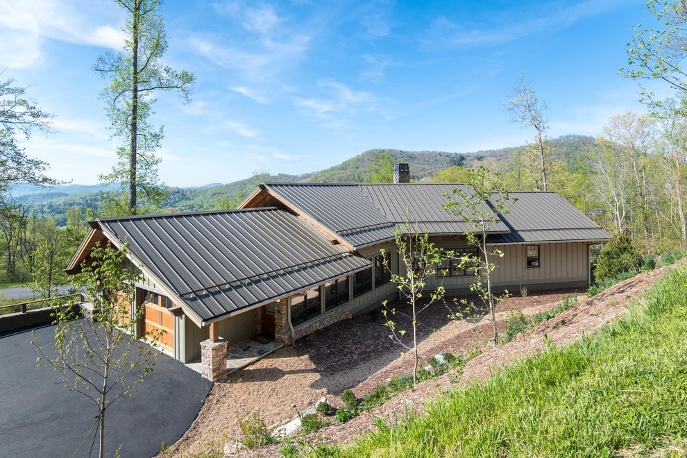 Large mountain style green two-story wood exterior home photo in Other with a metal roof