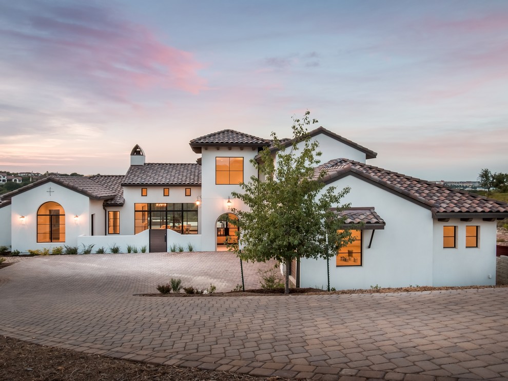 Zweistöckiges Mediterranes Einfamilienhaus mit weißer Fassadenfarbe, Walmdach und Ziegeldach in Austin