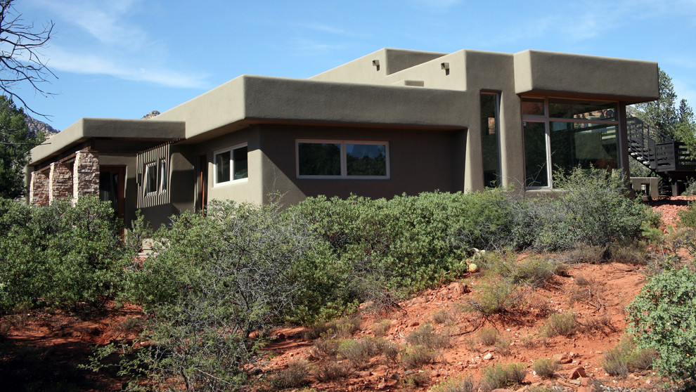 Exemple d'une façade de maison marron sud-ouest américain en stuc de taille moyenne et de plain-pied avec un toit plat.