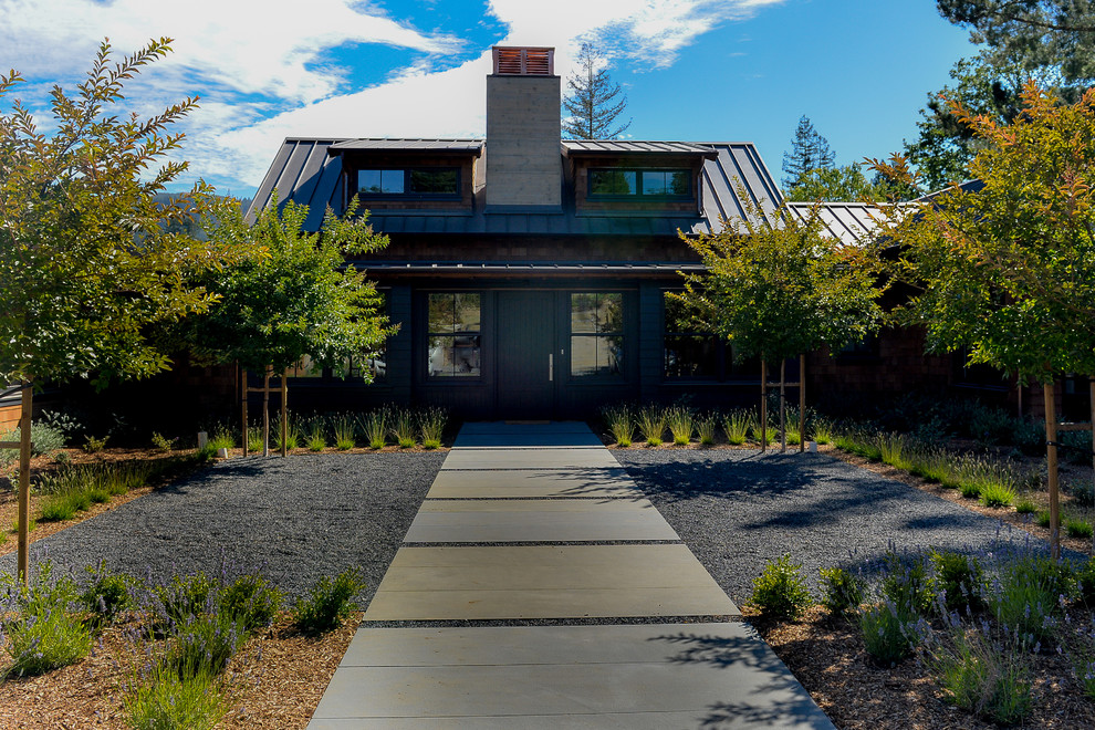 Foto de fachada de casa marrón rústica de tamaño medio de una planta con tejado de metal, tejado a dos aguas y revestimientos combinados