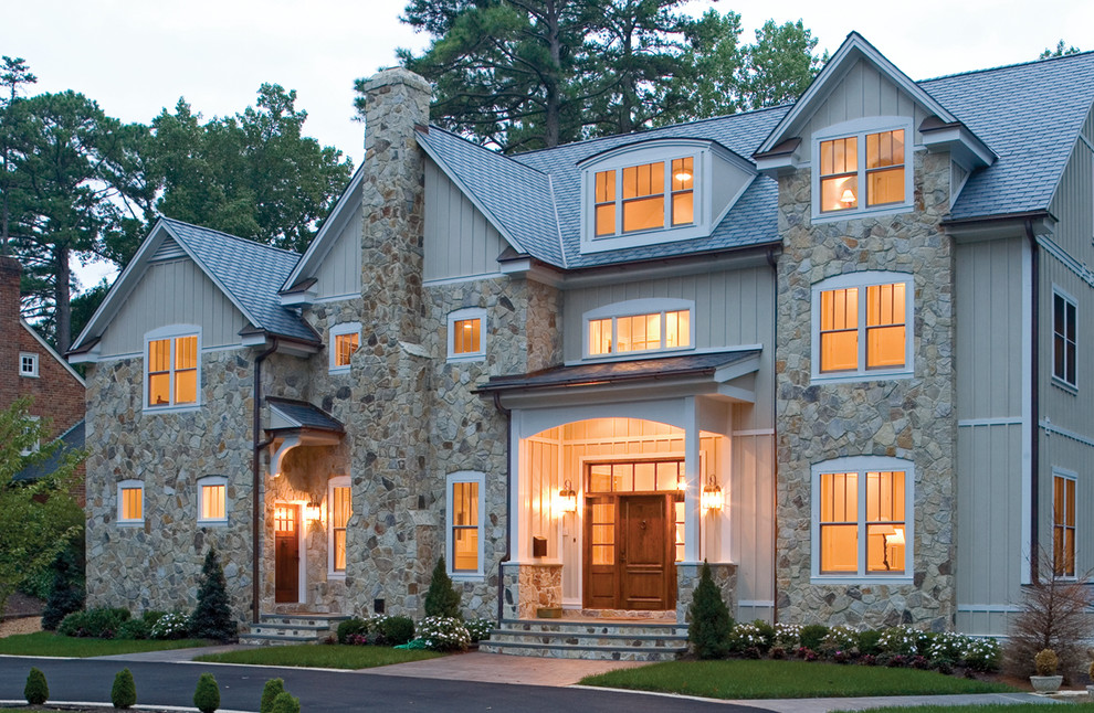 На фото: трехэтажный, серый дом в классическом стиле с комбинированной облицовкой и двускатной крышей с