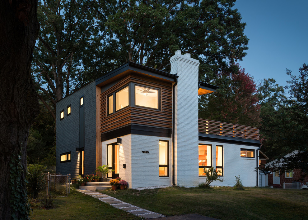 Idée de décoration pour une façade de maison multicolore design à un étage et de taille moyenne avec un revêtement mixte et un toit plat.