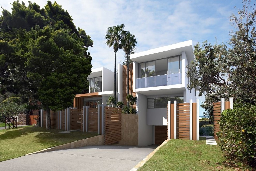 Idées déco pour une façade de maison blanche contemporaine en béton de taille moyenne et à un étage avec un toit plat.