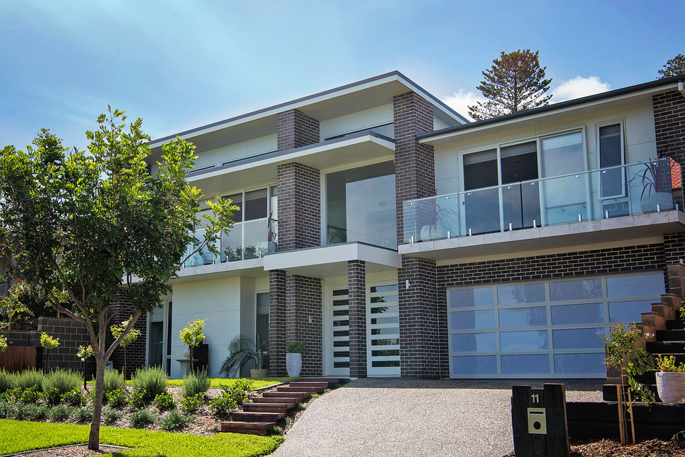 Modelo de fachada de casa multicolor costera de dos plantas con revestimiento de ladrillo, tejado plano y tejado de metal