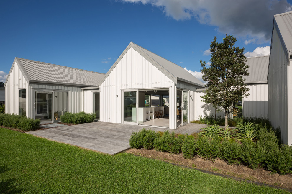 Mid-sized urban white one-story metal exterior home photo in Auckland with a metal roof
