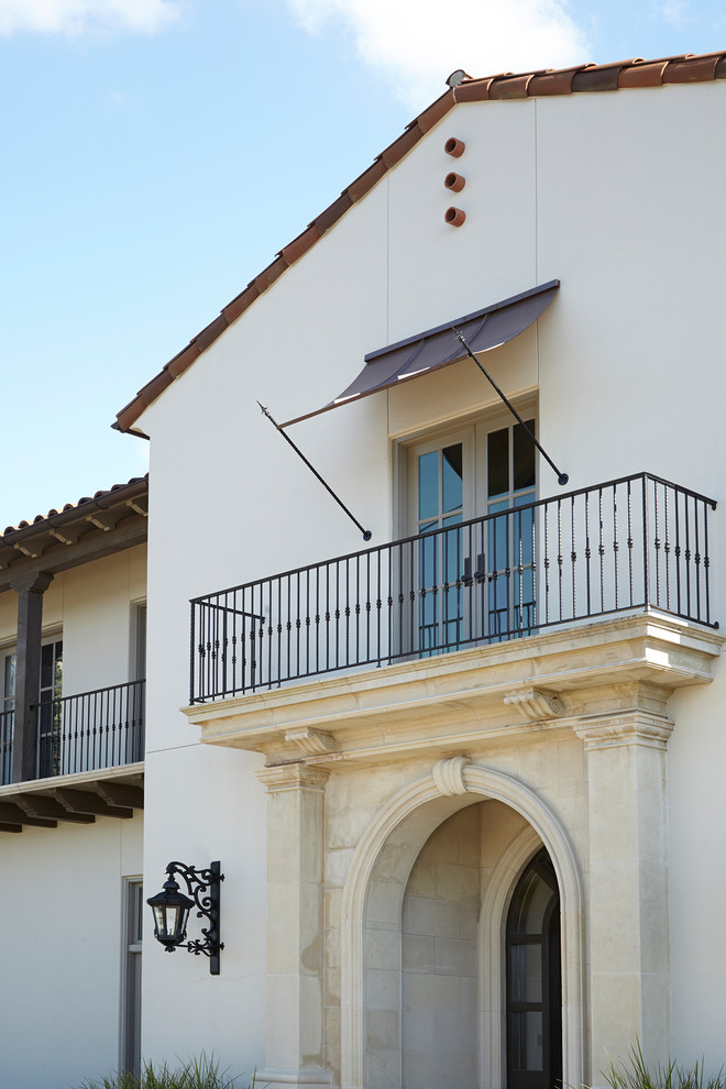Imagen de fachada de casa blanca mediterránea extra grande de dos plantas con revestimiento de estuco, tejado a dos aguas y tejado de teja de barro