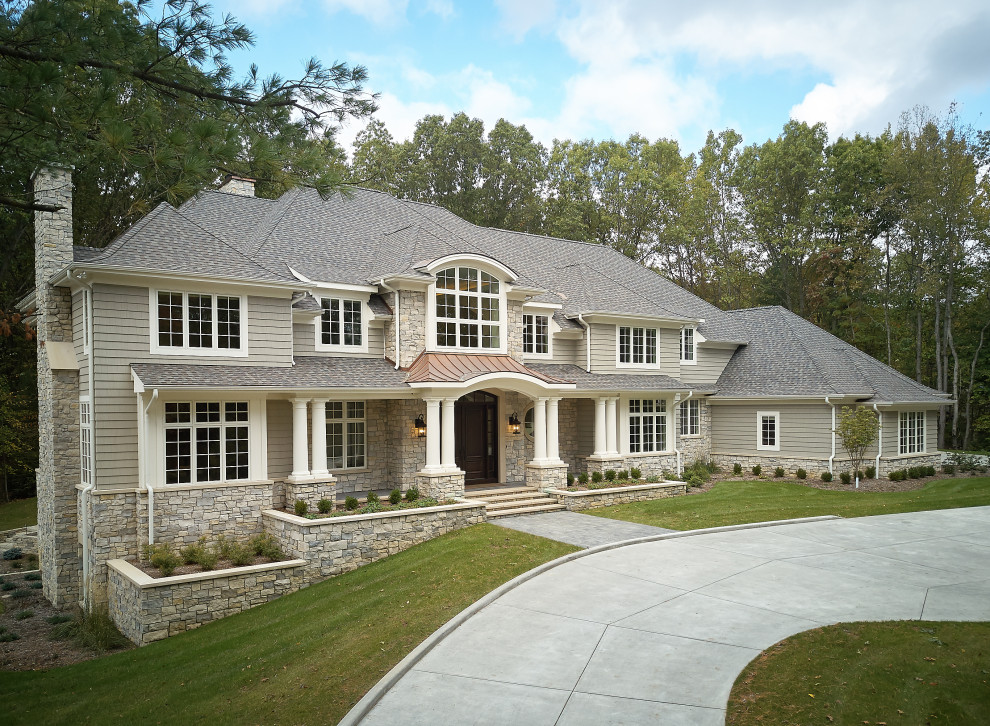 Modelo de fachada de casa beige y gris clásica grande de tres plantas con tejado a cuatro aguas, tejado de teja de madera y teja
