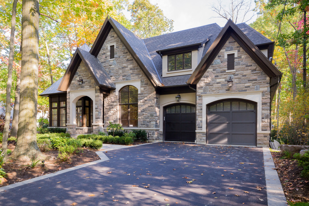 Large traditional two floor detached house in Toronto with stone cladding, a hip roof and a shingle roof.