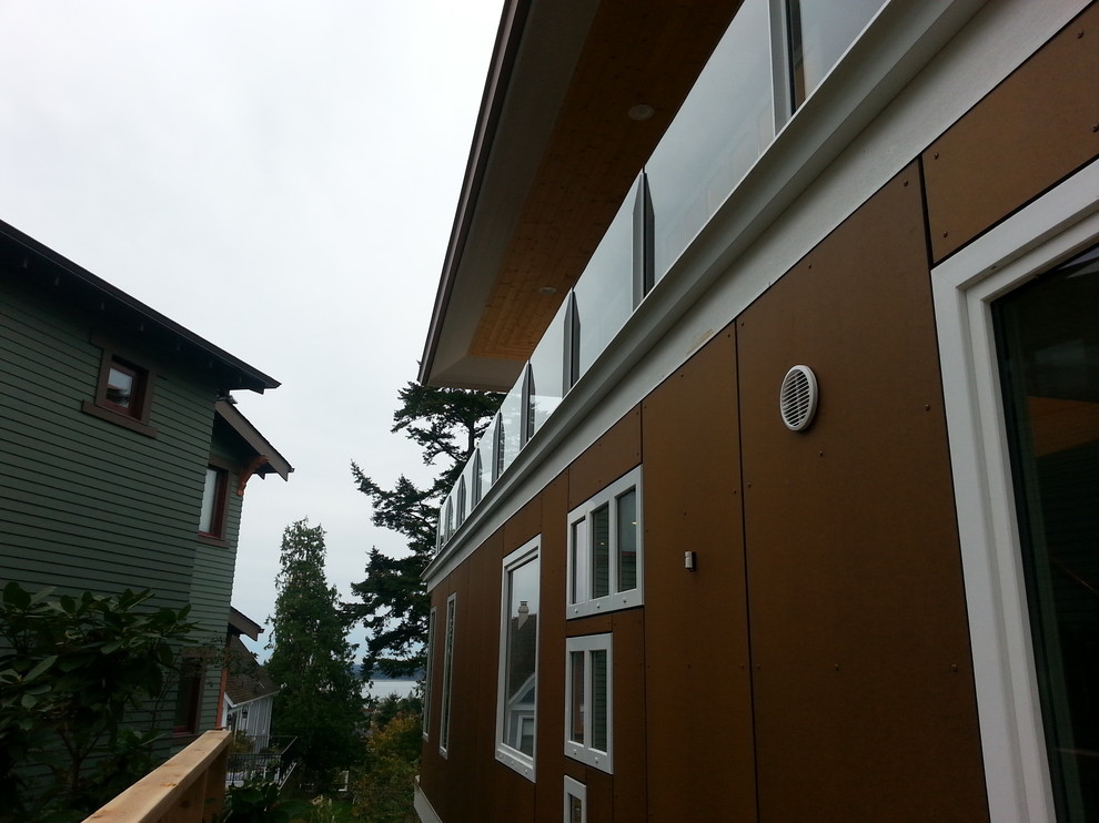 Inspiration for a medium sized and brown modern house exterior in Seattle with three floors and a flat roof.