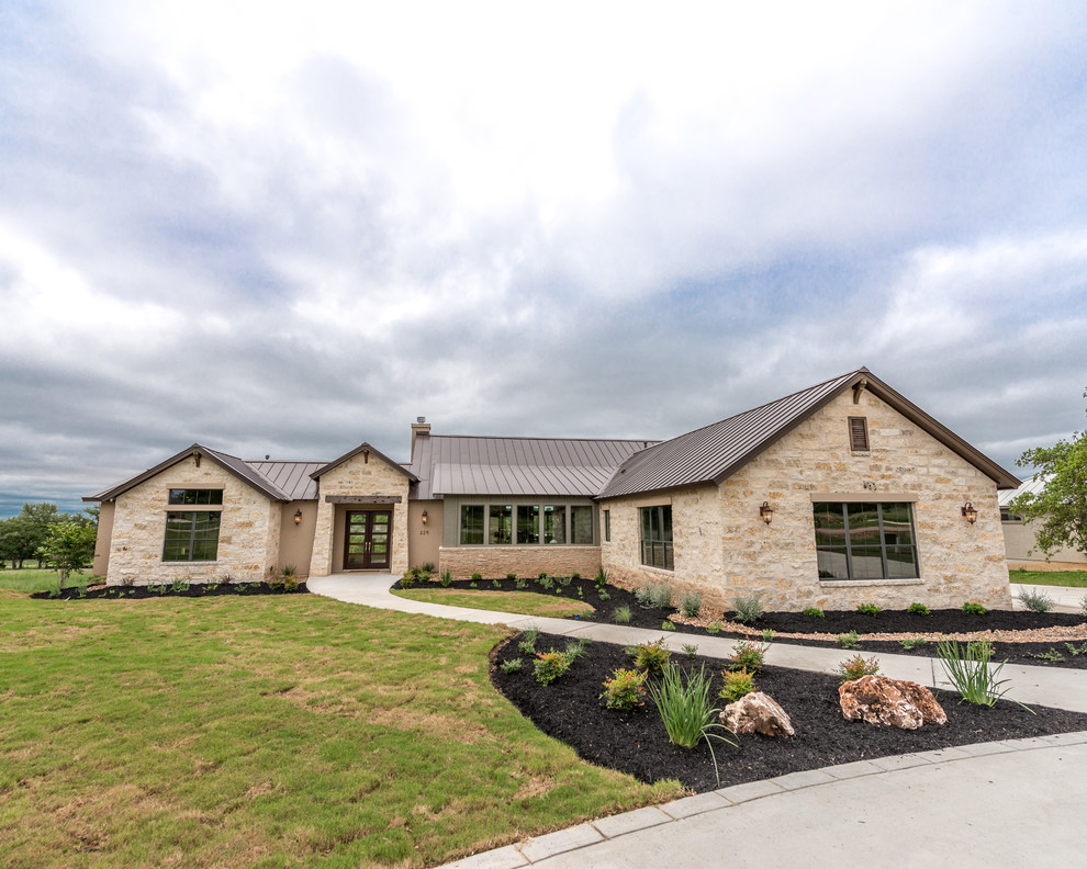 Large and beige classic bungalow house exterior in Austin with stone cladding and a pitched roof.