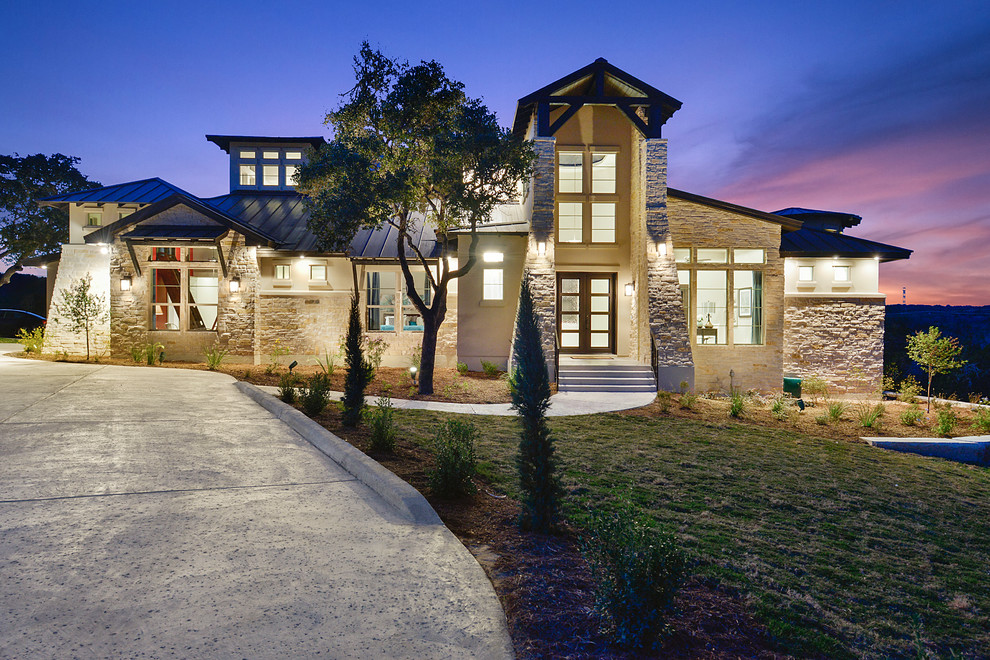 Inspiration for a large contemporary beige two-story stone exterior home remodel in Austin
