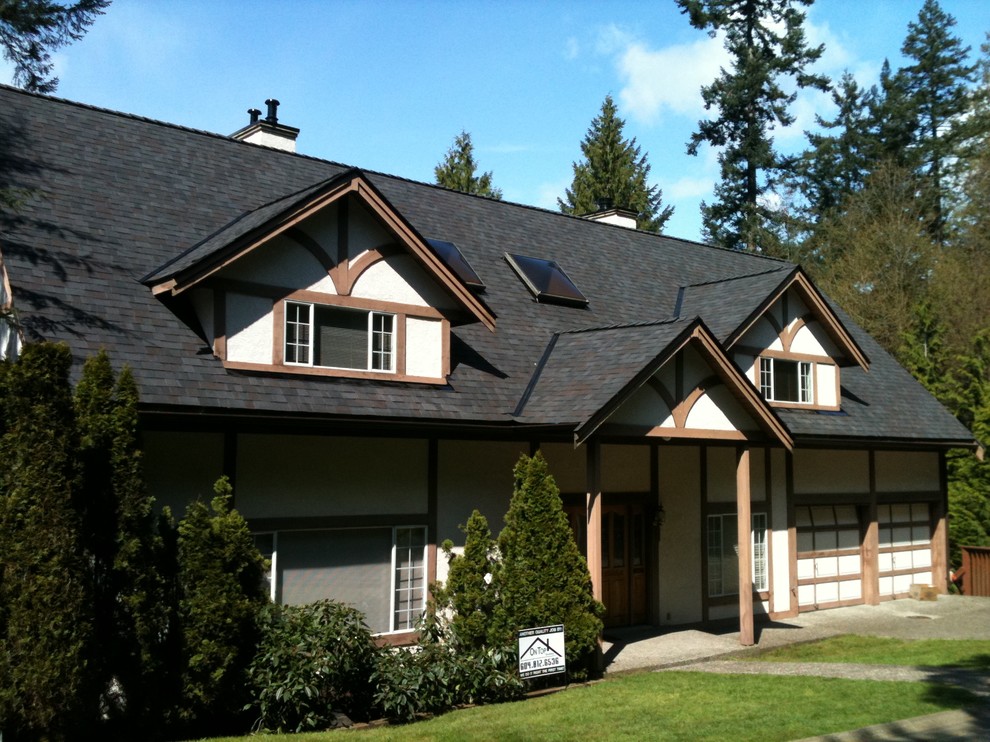 Modelo de fachada de casa tradicional de tamaño medio de dos plantas con revestimiento de estuco, tejado a dos aguas y tejado de teja de madera