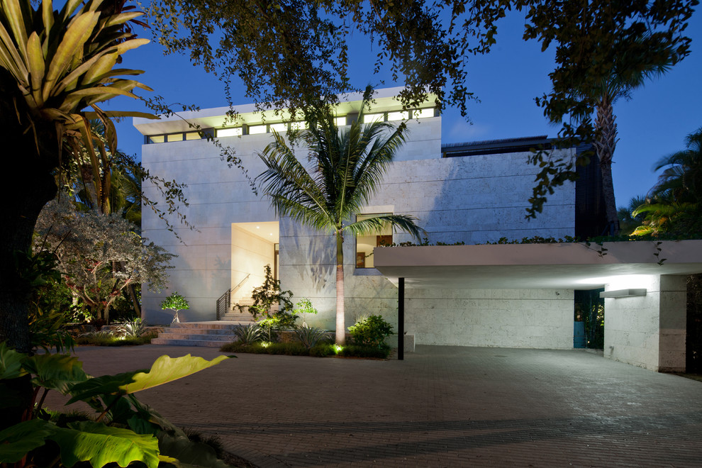 На фото: большой, двухэтажный, белый дом в современном стиле с облицовкой из камня и плоской крышей