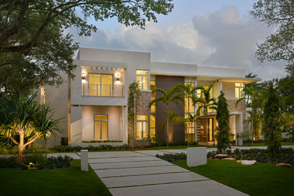На фото: большой, двухэтажный, белый многоквартирный дом в стиле модернизм с комбинированной облицовкой и плоской крышей с