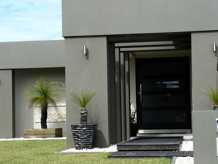 Example of a large minimalist green stucco flat roof design in Miami
