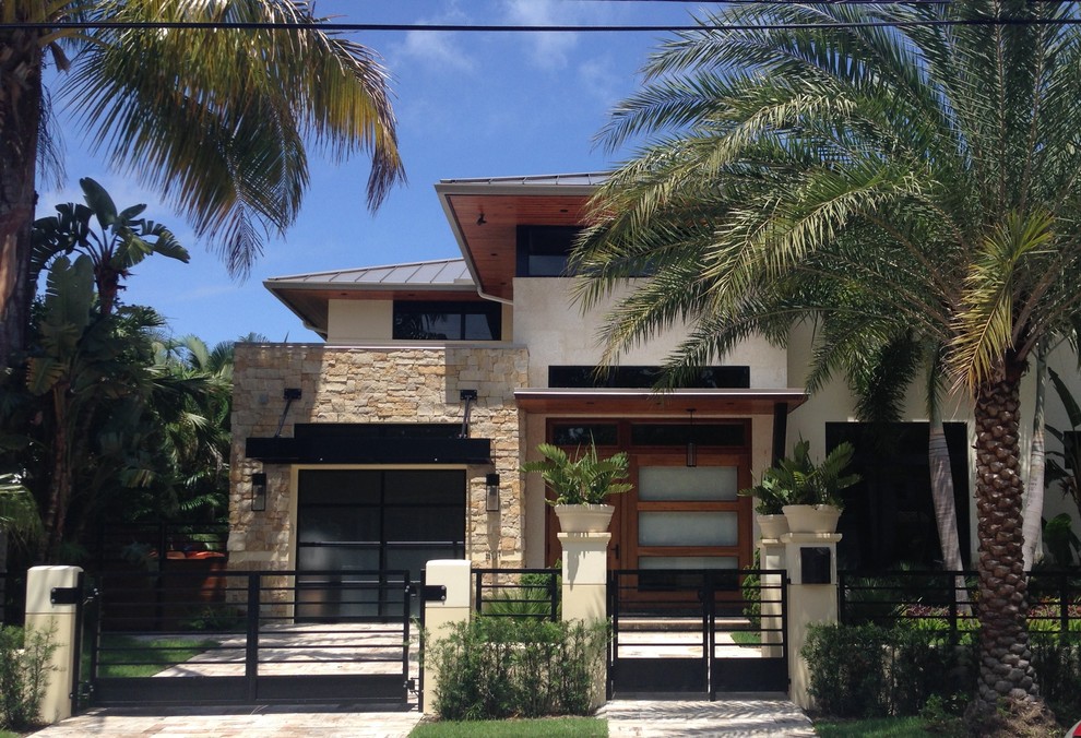 This is an example of a medium sized and beige modern two floor house exterior in Detroit.