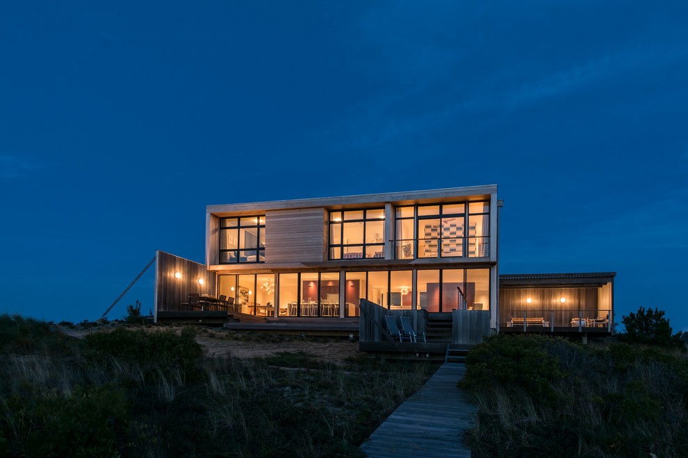 Réalisation d'une grande façade de maison beige minimaliste en bois à un étage avec un toit plat.