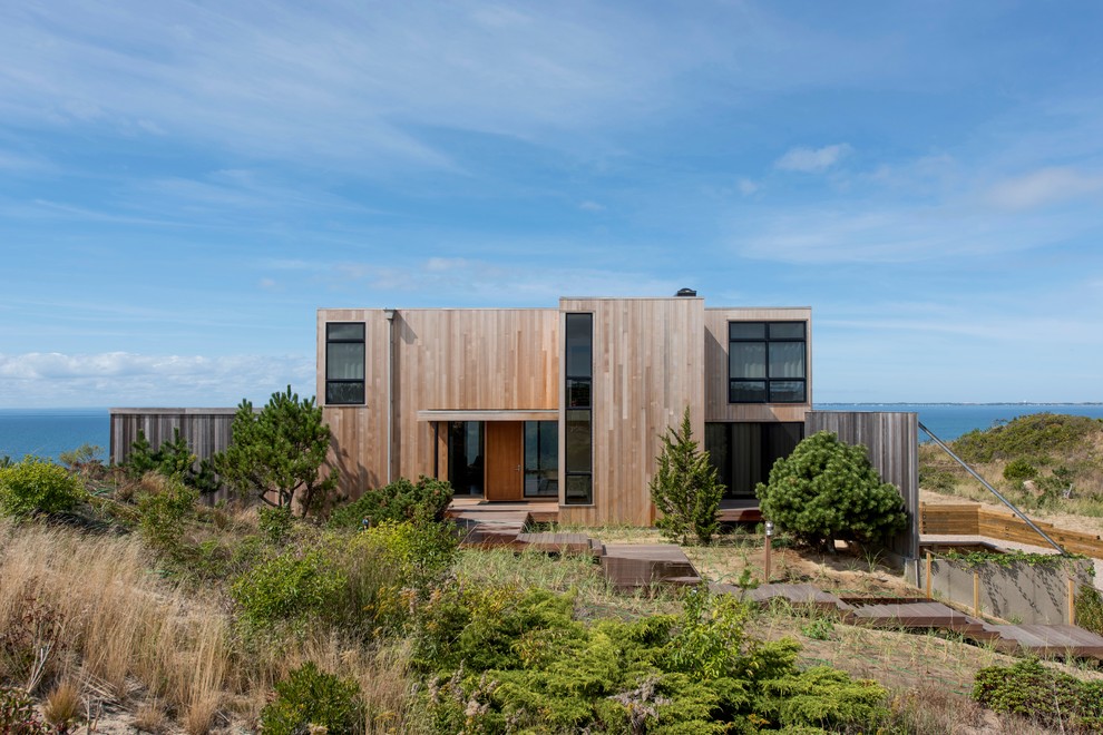 Modelo de fachada de casa beige minimalista grande de dos plantas con revestimiento de madera y tejado plano