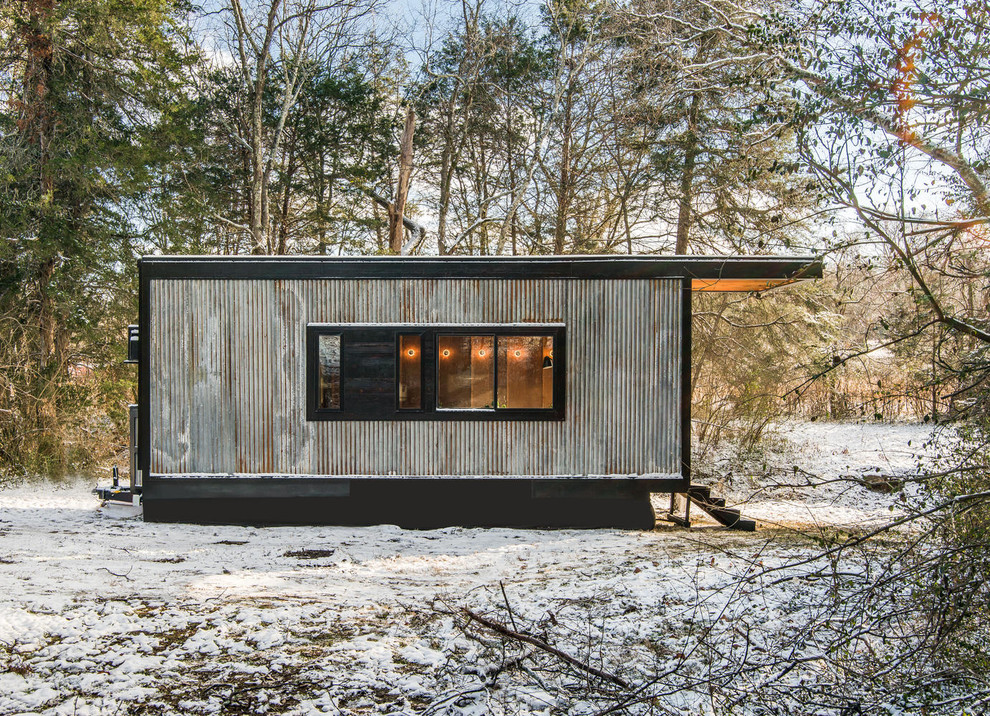 Стильный дизайн: одноэтажный, серый дом из контейнеров в стиле лофт с облицовкой из металла и плоской крышей - последний тренд