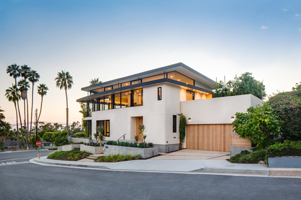 Large contemporary white two-story stucco exterior home idea in Orange County with a mixed material roof