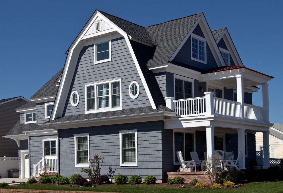 Imagen de fachada azul costera de tamaño medio de tres plantas con revestimiento de madera y tejado a doble faldón