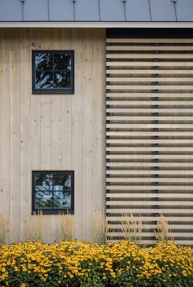 Modelo de fachada marrón de estilo de casa de campo extra grande de dos plantas con revestimiento de madera y tejado a dos aguas