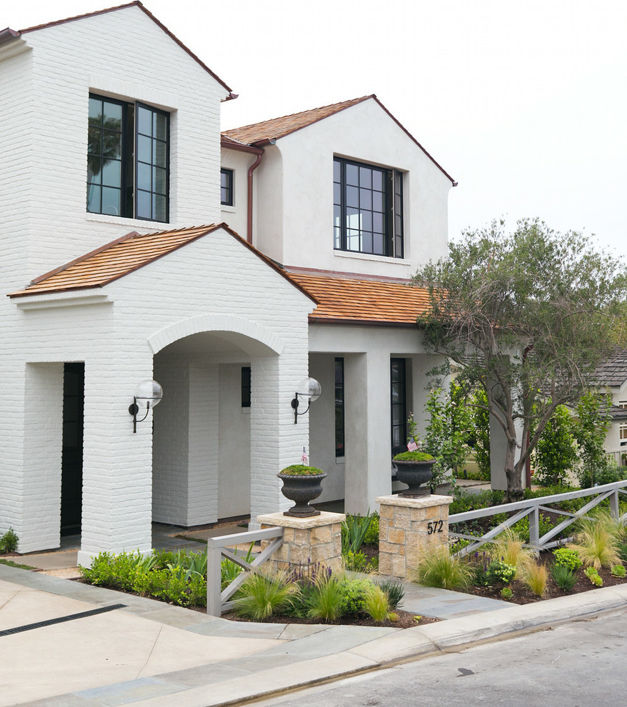 Design ideas for a large and white classic two floor brick house exterior in Orange County with a pitched roof.