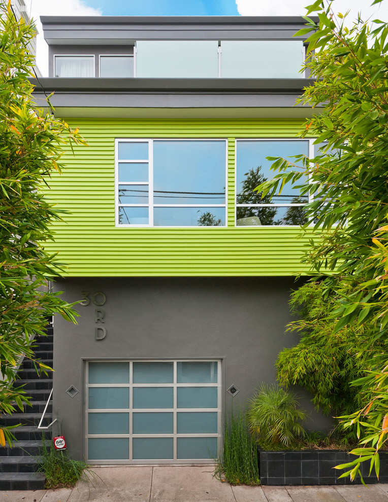 Esempio della facciata di una casa verde contemporanea con rivestimenti misti