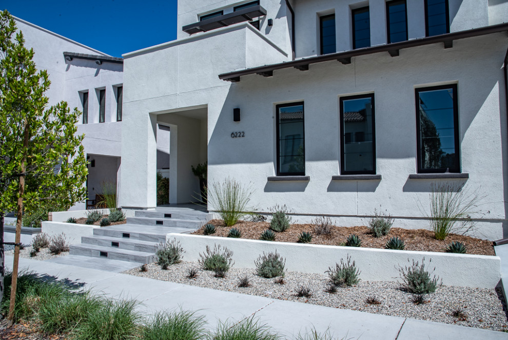 Mittelgroßes, Zweistöckiges Modernes Einfamilienhaus mit Putzfassade, weißer Fassadenfarbe, Flachdach und Schindeldach in San Diego