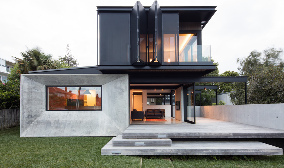 Photo of a retro concrete house exterior in Auckland with three floors and a lean-to roof.