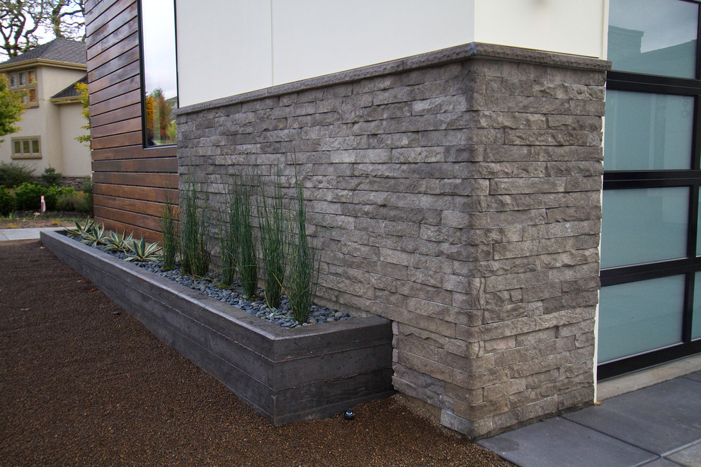 Ejemplo de fachada beige contemporánea de tamaño medio de dos plantas con revestimiento de piedra y tejado a cuatro aguas