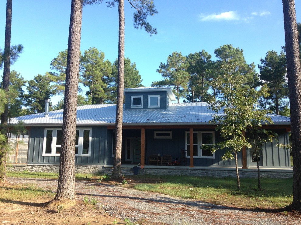 Diseño de fachada de casa azul rural de tamaño medio de una planta con revestimiento de aglomerado de cemento, tejado a cuatro aguas y tejado de metal