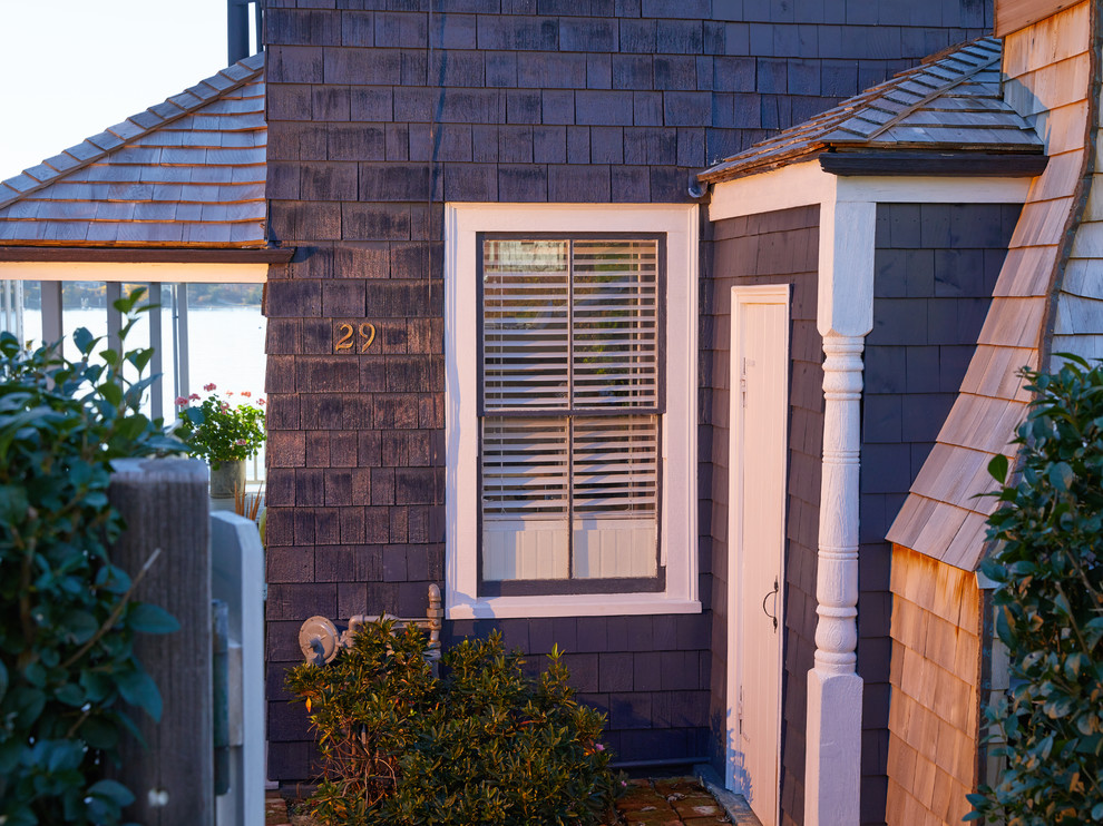 Imagen de fachada de casa azul de estilo de casa de campo pequeña de dos plantas con revestimiento de madera, tejado a doble faldón y tejado de teja de madera