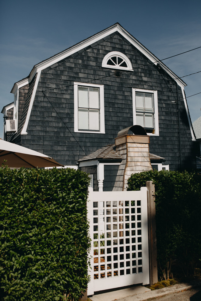 Immagine della villa piccola blu country a due piani con rivestimento in legno, tetto a mansarda e copertura a scandole