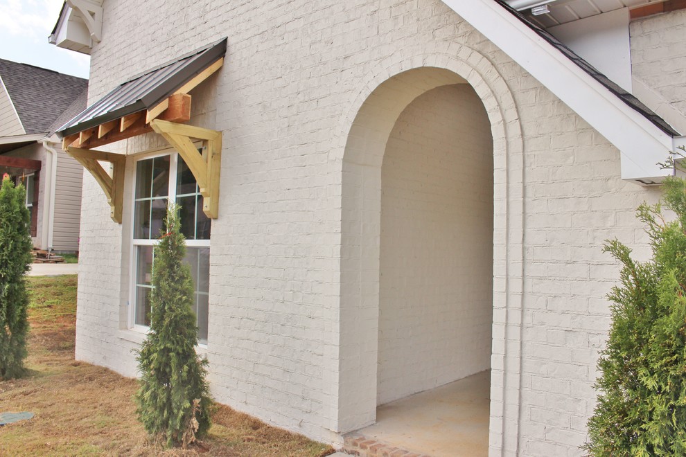 Modelo de fachada blanca clásica renovada de tamaño medio de una planta con revestimiento de ladrillo y tejado a cuatro aguas