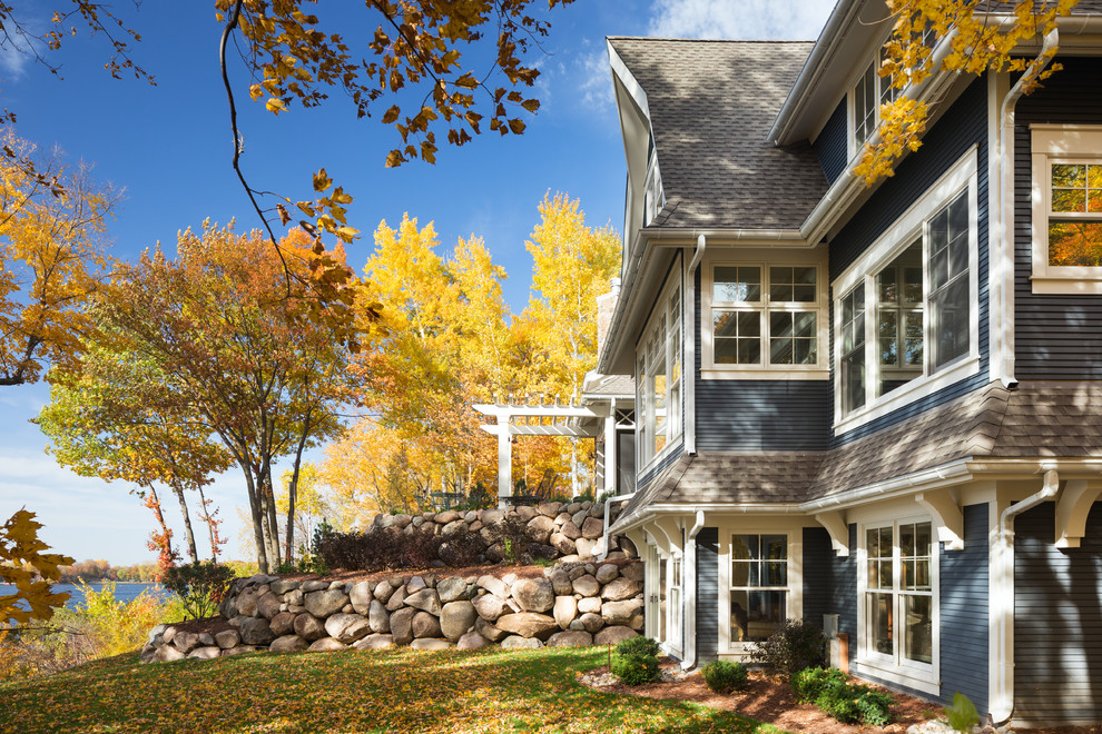 Example of a large classic blue three-story wood exterior home design in Minneapolis with a shingle roof
