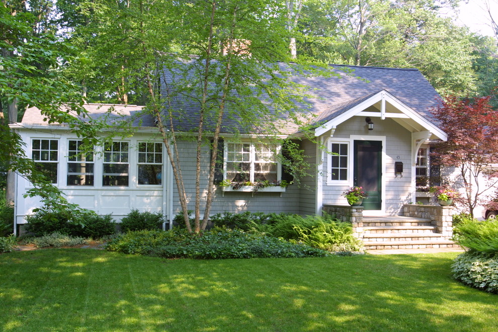 На фото: одноэтажный, деревянный, серый, маленький дом в классическом стиле с двускатной крышей для на участке и в саду