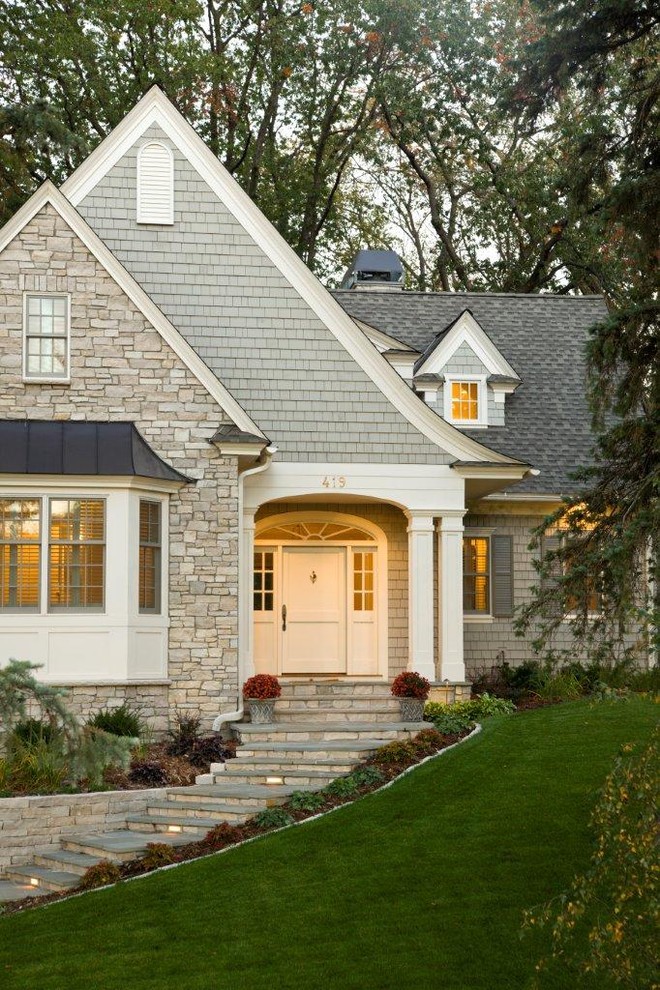Inspiration for a traditional two floor house exterior in Minneapolis with wood cladding.