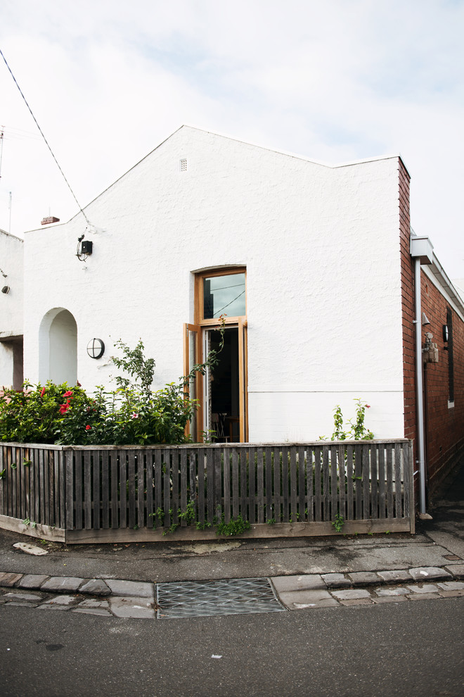 Foto på ett mellanstort eklektiskt vitt hus, med två våningar, tegel och pulpettak