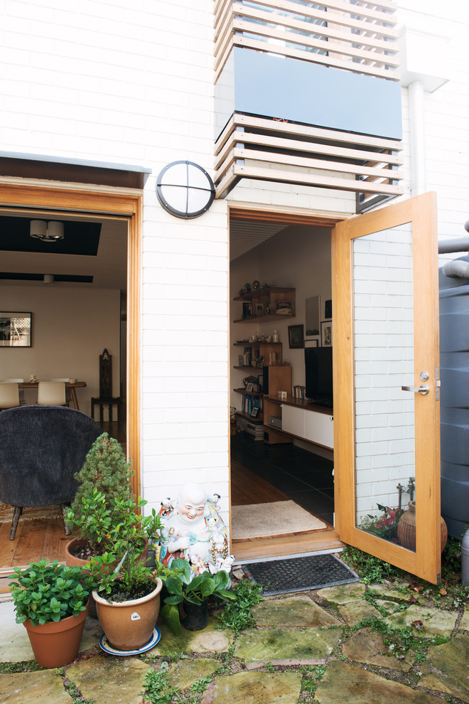 Medium sized and white eclectic two floor brick house exterior in Melbourne with a lean-to roof.