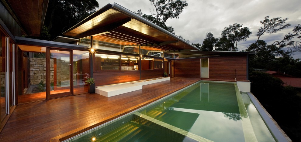 Idée de décoration pour une grande façade de maison marron design en bois à un étage.